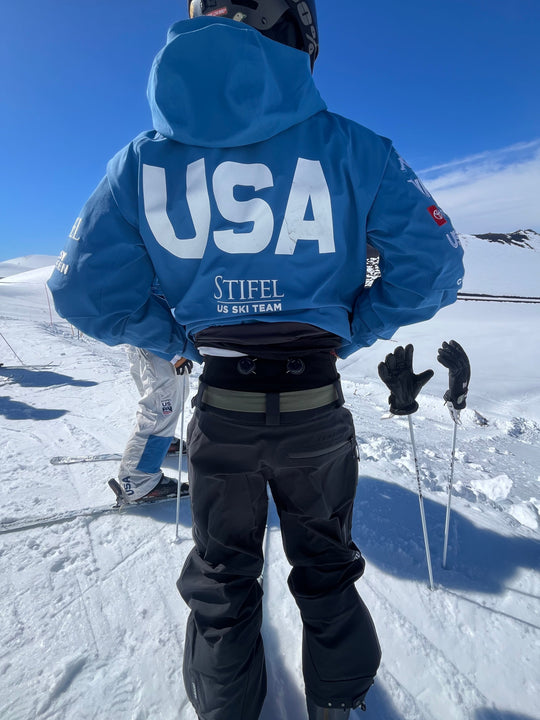 Person in a blue jacket with 'USA' branding on a snowy slope